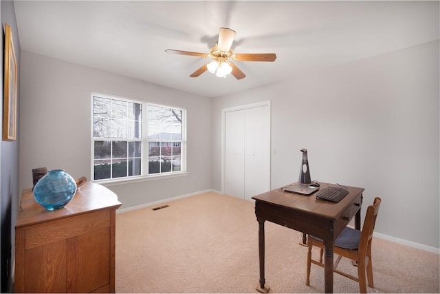 office space featuring visible vents, baseboards, a ceiling fan, and carpet floors