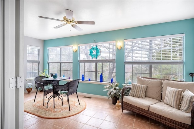 sunroom / solarium with a ceiling fan, a healthy amount of sunlight, and visible vents