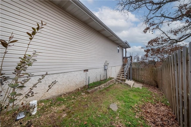 view of property exterior featuring stairway, a fenced backyard, and crawl space