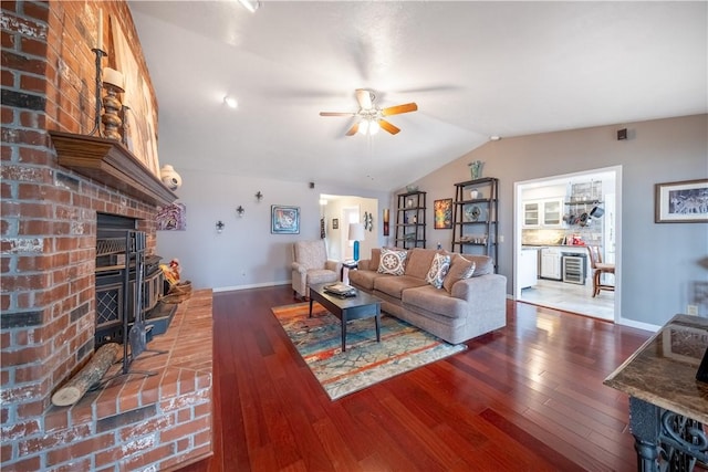 living area featuring beverage cooler, a brick fireplace, hardwood / wood-style flooring, and vaulted ceiling