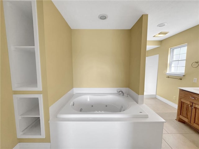 bathroom with tile patterned flooring, visible vents, a jetted tub, baseboards, and vanity