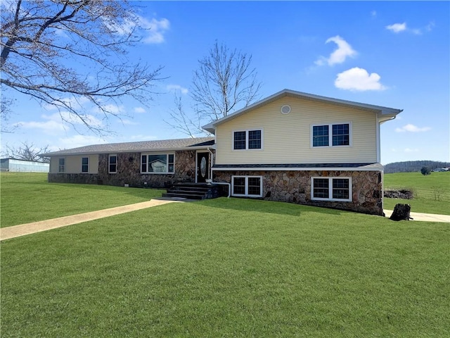 split level home with stone siding and a front lawn