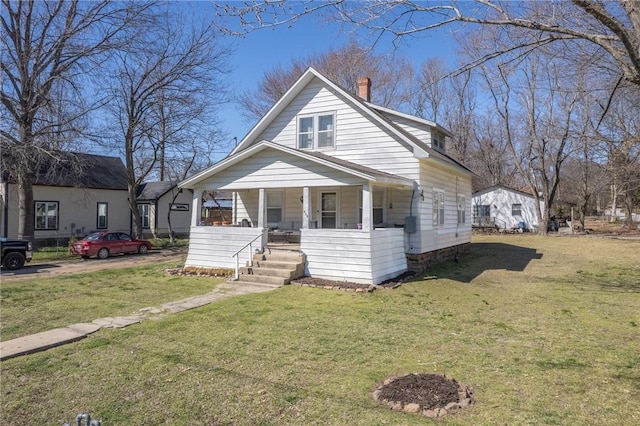 bungalow-style house with a front lawn, covered porch, and a chimney