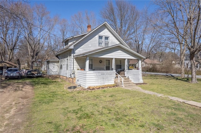 bungalow-style house with covered porch, driveway, a chimney, and a front lawn