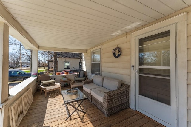 wooden terrace with an outdoor living space and covered porch