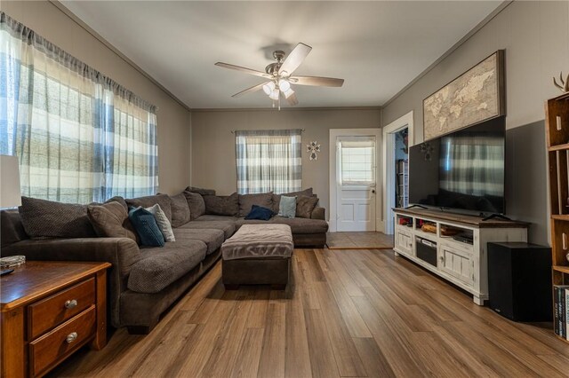 living area with crown molding, ceiling fan, and wood finished floors