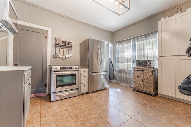 kitchen with cooling unit, appliances with stainless steel finishes, light tile patterned flooring, crown molding, and light countertops