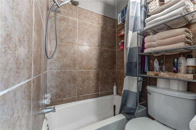 bathroom with shower / bath combination with curtain and toilet