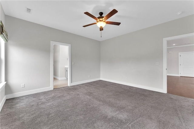 unfurnished bedroom featuring dark carpet, baseboards, ceiling fan, and visible vents