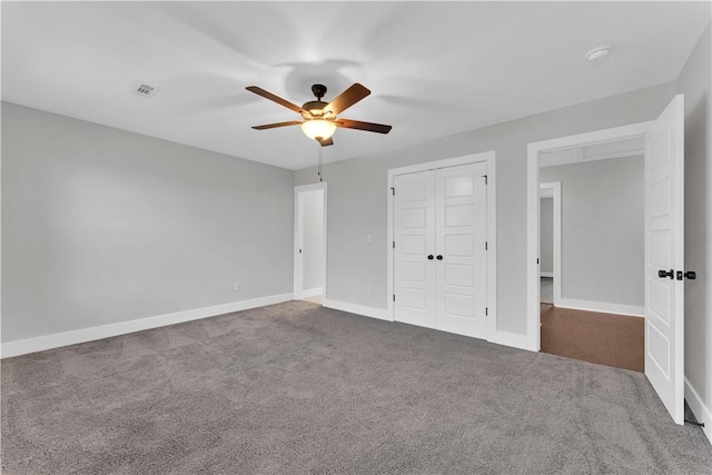 unfurnished bedroom with visible vents, a closet, baseboards, a ceiling fan, and carpet