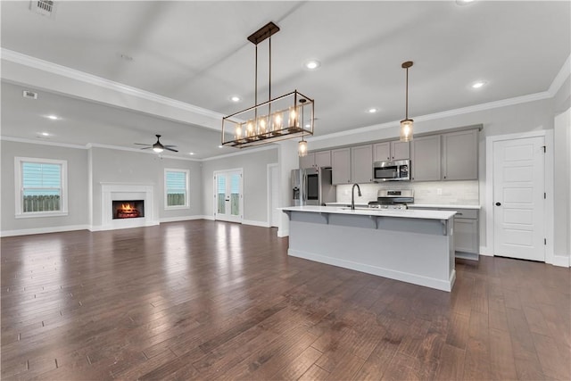 kitchen featuring a sink, light countertops, stainless steel appliances, gray cabinetry, and dark wood-style floors