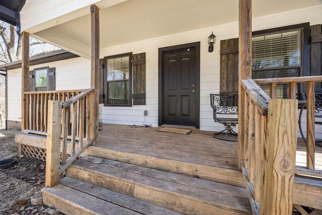 view of exterior entry featuring covered porch