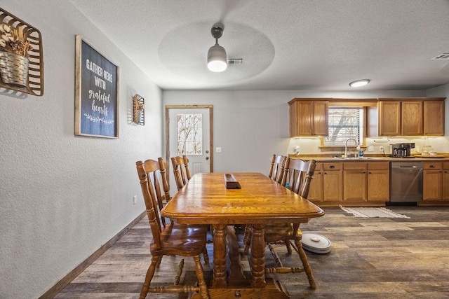 dining area featuring a textured wall, baseboards, dark wood-type flooring, and a textured ceiling