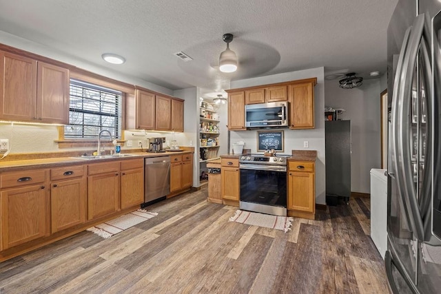 kitchen featuring a sink, stainless steel appliances, visible vents, and light wood finished floors