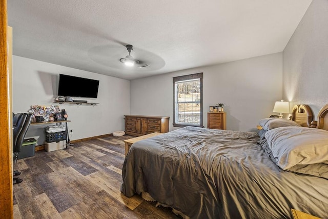 bedroom featuring a ceiling fan, visible vents, wood finished floors, baseboards, and a textured ceiling