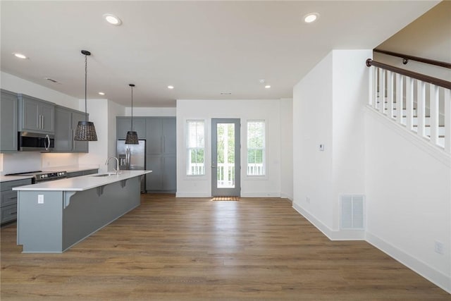 kitchen featuring visible vents, gray cabinets, wood finished floors, recessed lighting, and stainless steel appliances