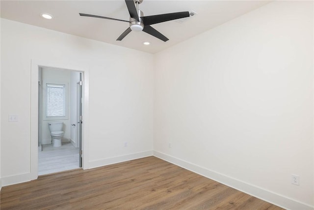 unfurnished room featuring recessed lighting, wood finished floors, and baseboards