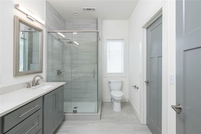 full bathroom with vanity, baseboards, visible vents, a shower stall, and toilet