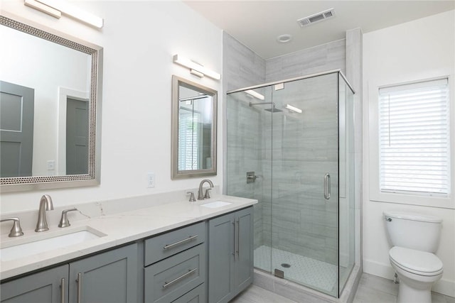 full bath with visible vents, a shower stall, toilet, and a sink