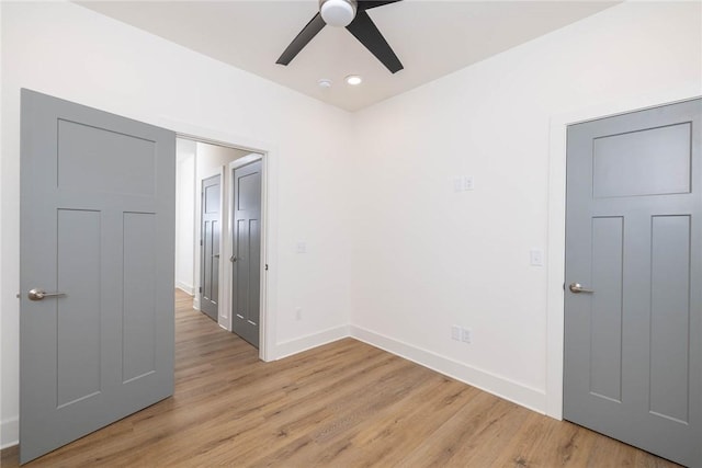 empty room featuring light wood finished floors, ceiling fan, and baseboards