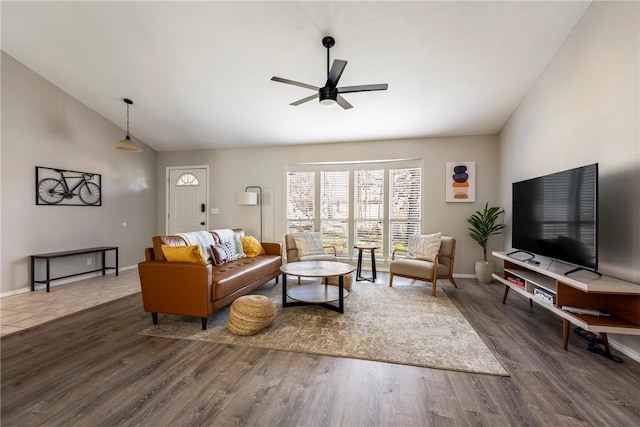 living area featuring a ceiling fan, wood finished floors, baseboards, and high vaulted ceiling