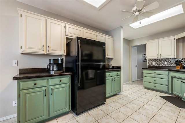 kitchen featuring dark countertops, a ceiling fan, tasteful backsplash, and freestanding refrigerator