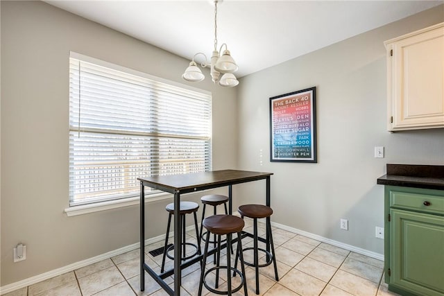 dining room with baseboards, an inviting chandelier, and light tile patterned flooring