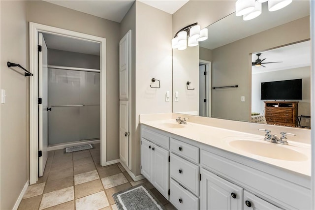 bathroom featuring ceiling fan, double vanity, baseboards, and a sink