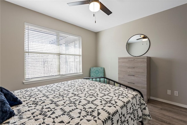 bedroom with a ceiling fan, baseboards, and wood finished floors