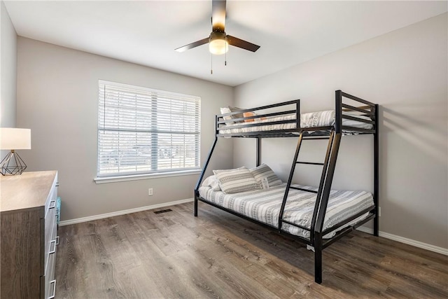 bedroom with visible vents, baseboards, dark wood-style flooring, and ceiling fan