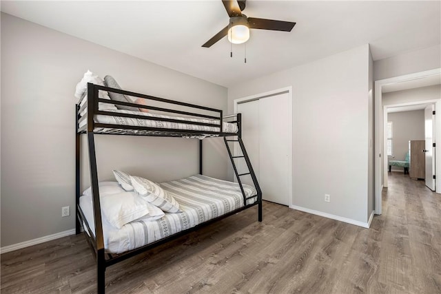 bedroom with a closet, baseboards, and wood finished floors