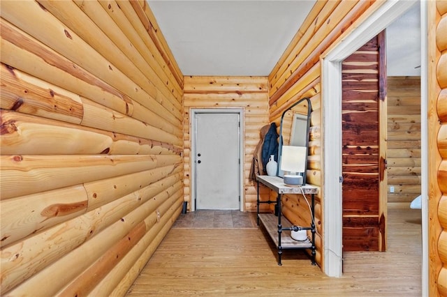 hallway featuring rustic walls and light wood-style flooring