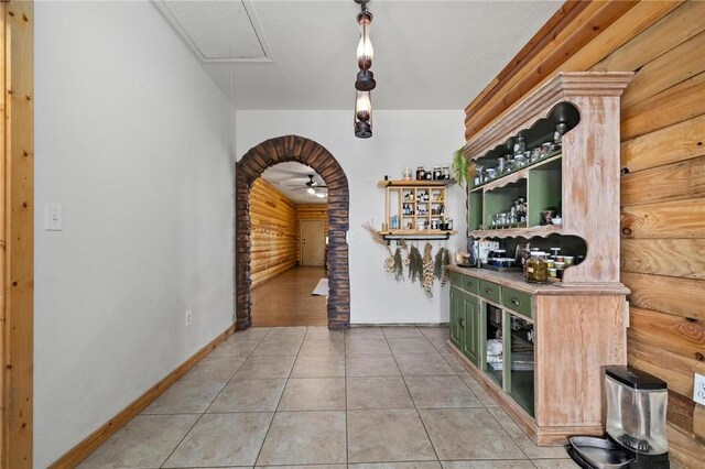 interior space with light tile patterned floors, arched walkways, and attic access