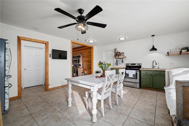 dining space featuring light tile patterned floors, a ceiling fan, and baseboards