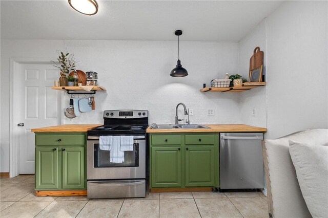 kitchen with wooden counters, open shelves, a sink, stainless steel appliances, and green cabinets