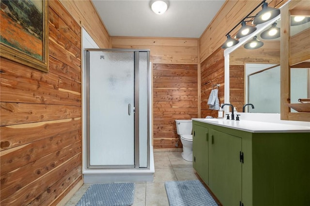 bathroom featuring vanity, tile patterned flooring, a shower stall, wood walls, and toilet