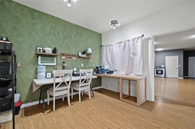 dining area with baseboards and wood finished floors