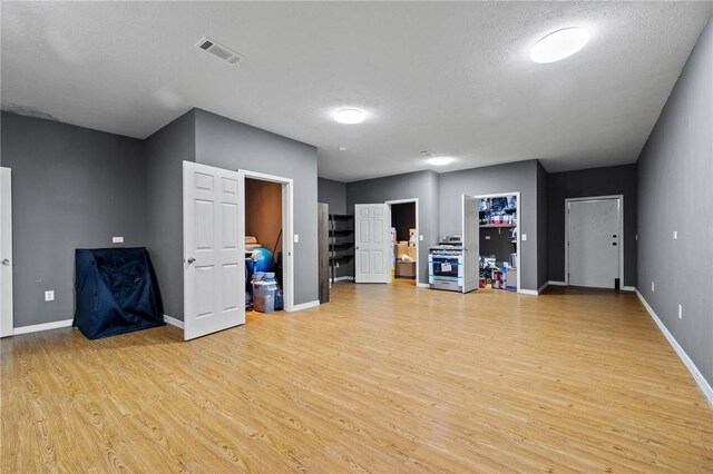 interior space with light wood-style floors, visible vents, and baseboards