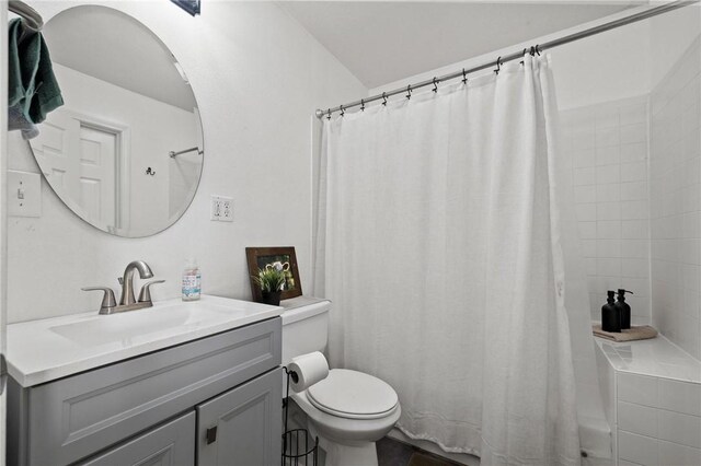 bathroom featuring curtained shower, toilet, and vanity