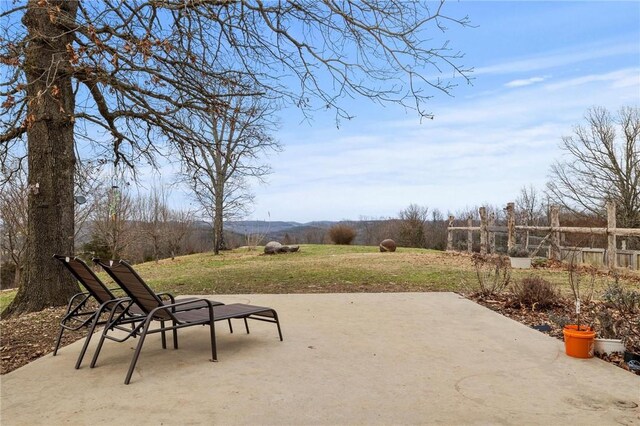 view of patio / terrace with a rural view and fence