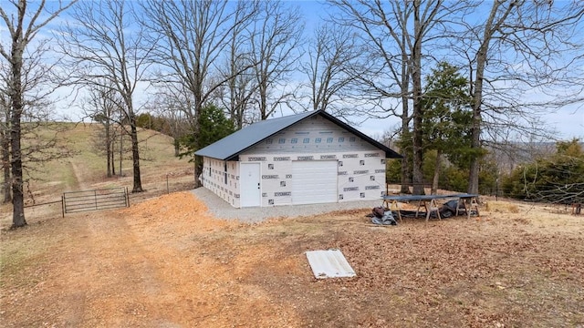 exterior space with a garage, an outbuilding, and fence