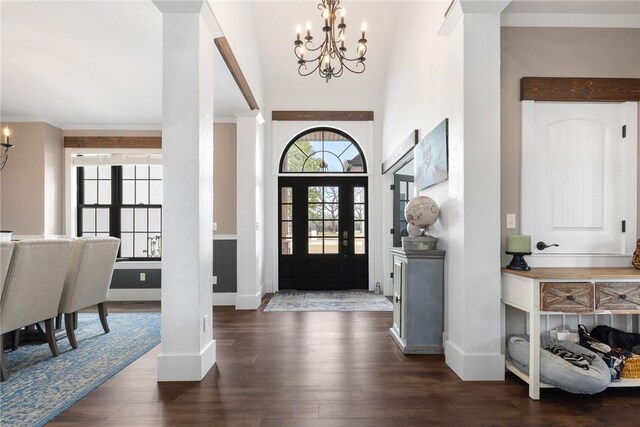 entryway featuring a notable chandelier, wood finished floors, baseboards, and ornamental molding