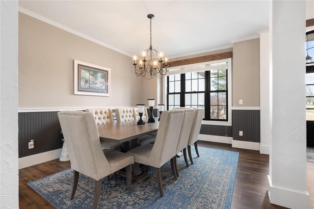 dining room with a wainscoted wall, a notable chandelier, ornamental molding, and dark wood finished floors