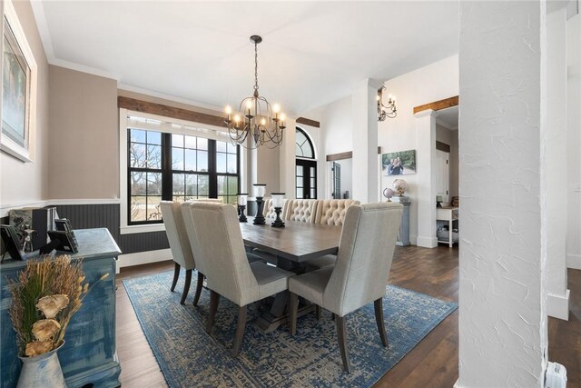 dining room with crown molding, wood finished floors, a wainscoted wall, and a chandelier