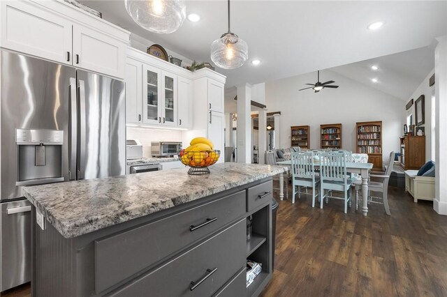 kitchen featuring open floor plan, lofted ceiling, white cabinets, stainless steel fridge, and a ceiling fan