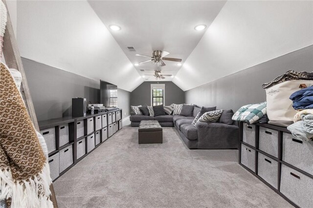 carpeted living room featuring lofted ceiling, a ceiling fan, and visible vents