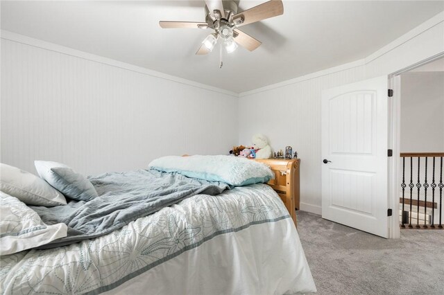 carpeted bedroom with crown molding and a ceiling fan