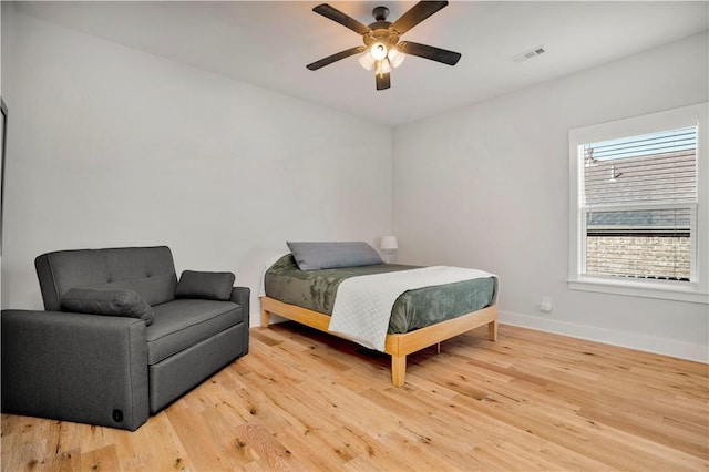 bedroom with visible vents, light wood-style flooring, baseboards, and ceiling fan