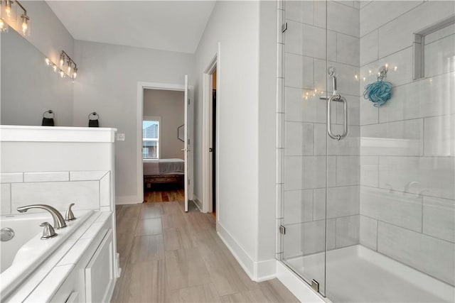 bathroom featuring a bath, a shower stall, connected bathroom, and baseboards