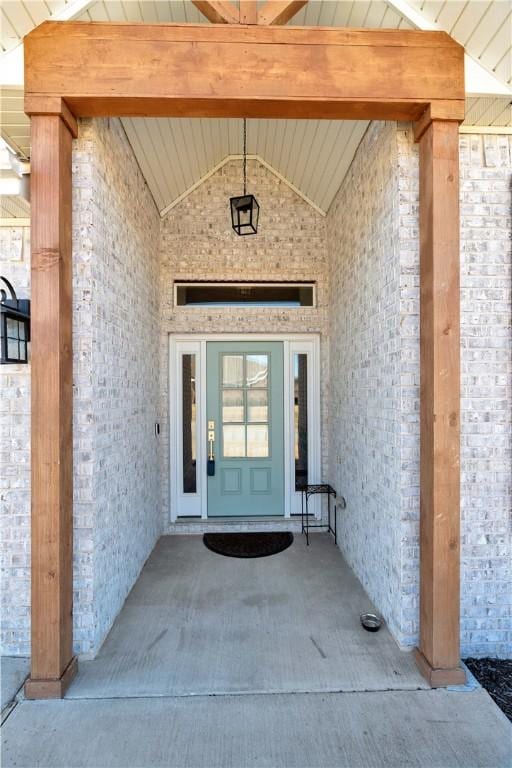 doorway to property featuring brick siding